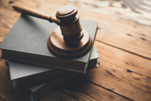 law book with a wooden judges gavel on table